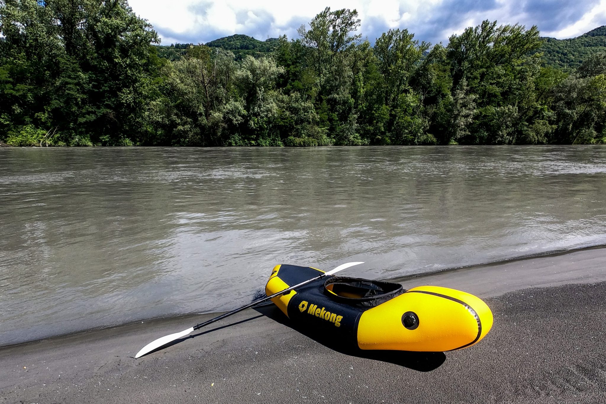 Packraft Mekong posé sur le sable noir au bord de l'Isère