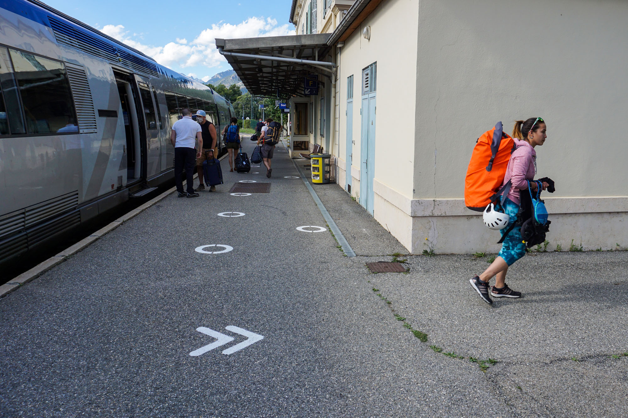 Demoiselle avec son packraft dans son sac à dos sur le quai d'une gare